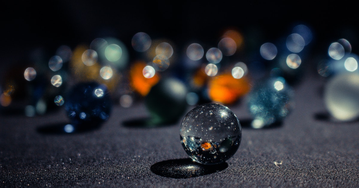 Closeup shot of marbles on a dark sheet